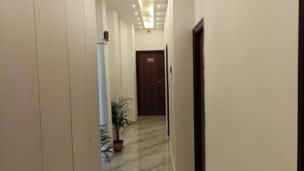 A hallway with a marble floor, recessed lighting, and a door marked "2201". - A28 Orange Bricks (Kolkata)