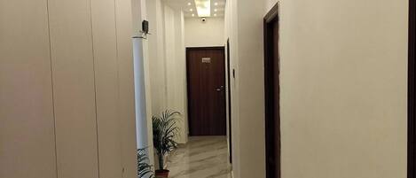 A hallway with a marble floor, recessed lighting, and a door marked "2201".