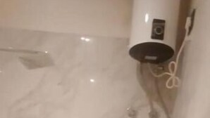 A marble floor with a wall-mounted device and a power cord. - A28 Orange Bricks (Kolkata)