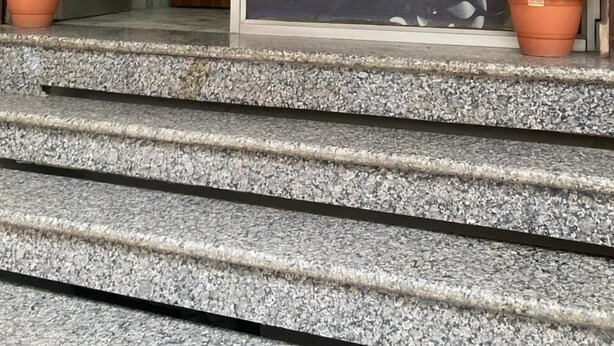 A reception area with a 'Welcome Reception' sign, a staircase, and two potted plants. - Hotel Krishna Inn (Karchana)