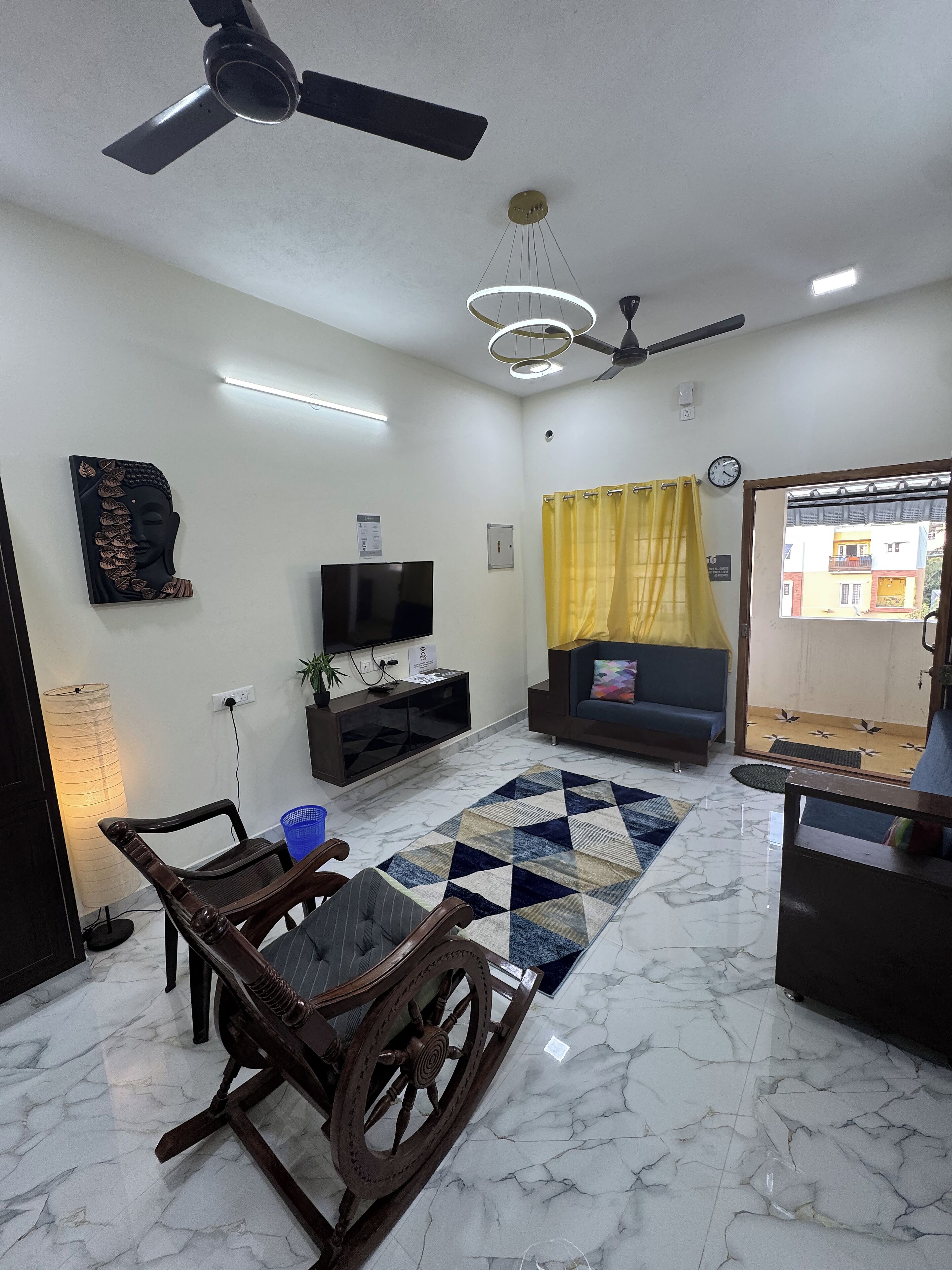 A living room with a TV, sofa, and a decorative wall piece.