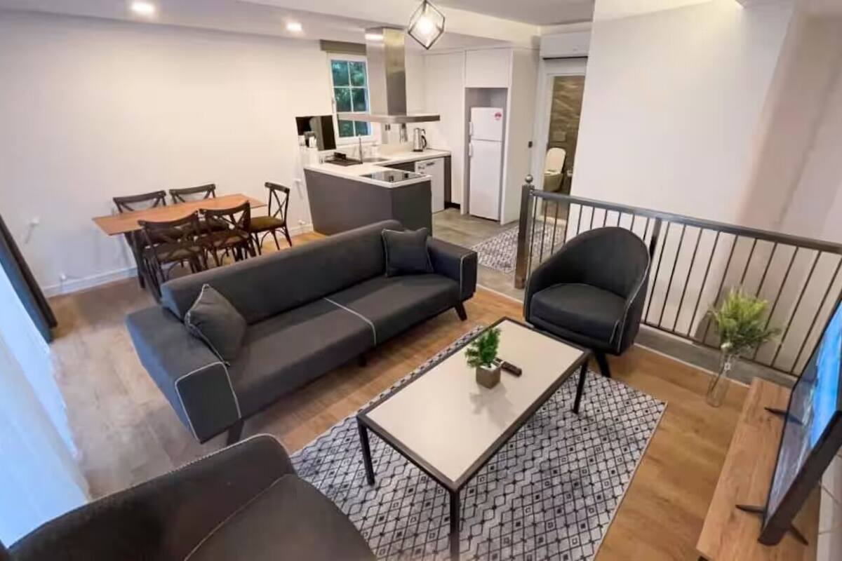 Un appartamento moderno con soggiorno, zona pranzo, cucina e un balcone.