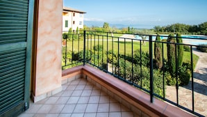 A balcony with a view of a swimming pool and a building in the background. - Suite Panorama Puegnago (Puegnago del Garda)