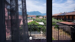 Ein Balkon mit Blick auf ein Wohngebiet, inklusive Häuser und Berge im Hintergrund.