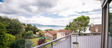 Un balcón con vistas a una zona residencial y un cuerpo de agua.