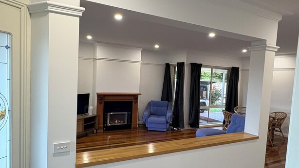 Una sala de estar moderna con chimenea, un sofá azul y una mesa de centro de madera.