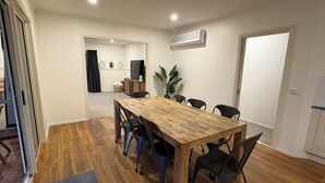Un comedor con una mesa y sillas de madera, un televisor y una planta en maceta.