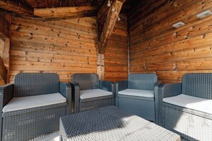 A wooden interior with wicker furniture and a bench. - Hameau des clos Téléporté (Les Gets)