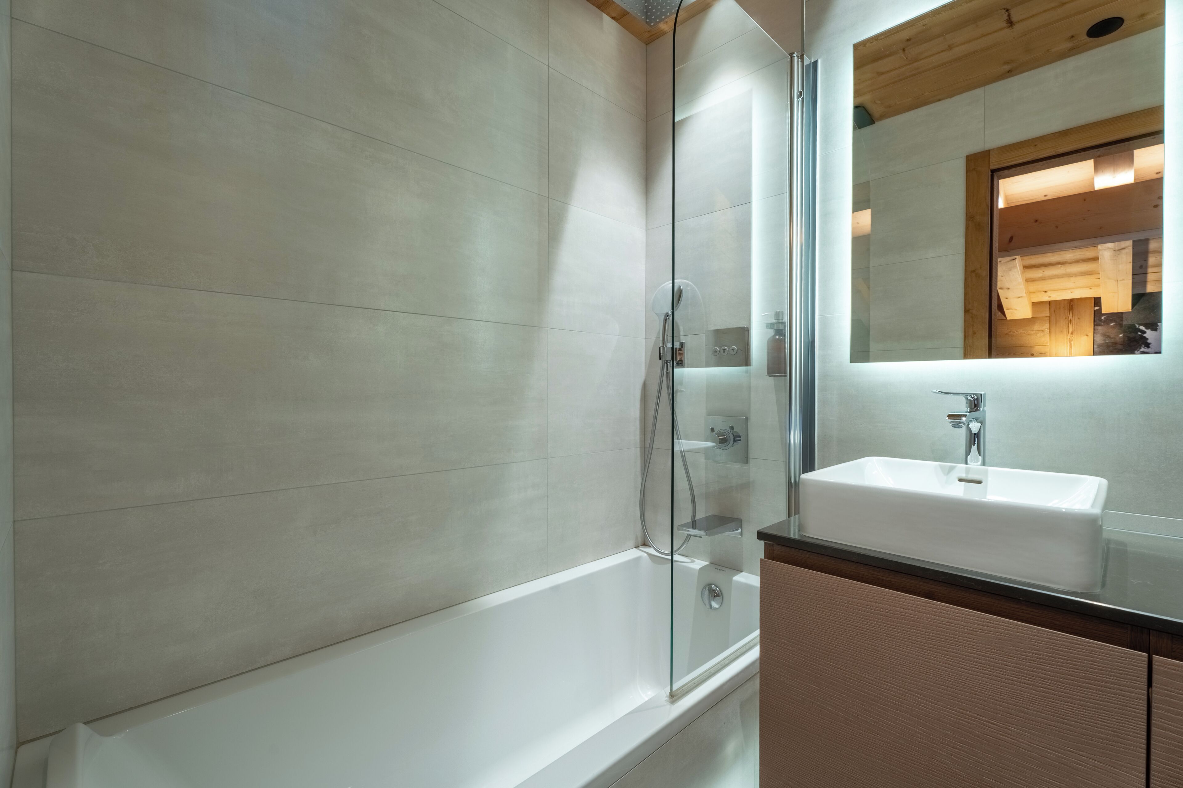 Une salle de bain moderne avec une douche à parois de verre, un lavabo blanc et un plafond en bois.
