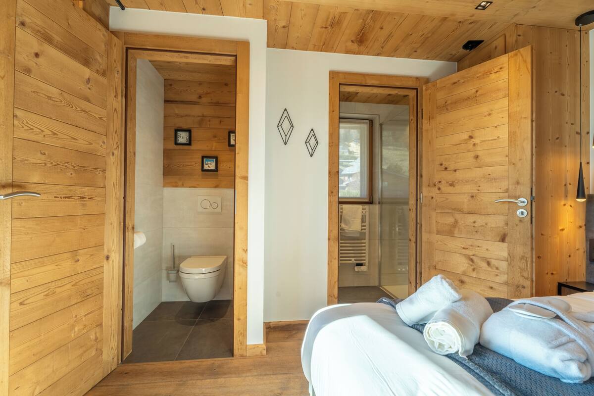 Huoneessa on puulattia, sänky, wc ja suihkutila.