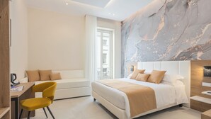 Une chambre d’hôtel moderne équipée d’un lit, d’un bureau, d’une chaise et d’un grand mur en marbre.