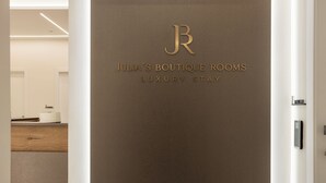 Une porte ornée d’un logo et de l’inscription « Julia’s Boutique Rooms, hébergement de luxe ».