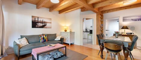 Una sala de estar acogedora con un sofá, una mesa de centro y un comedor con sillas y una mesa.