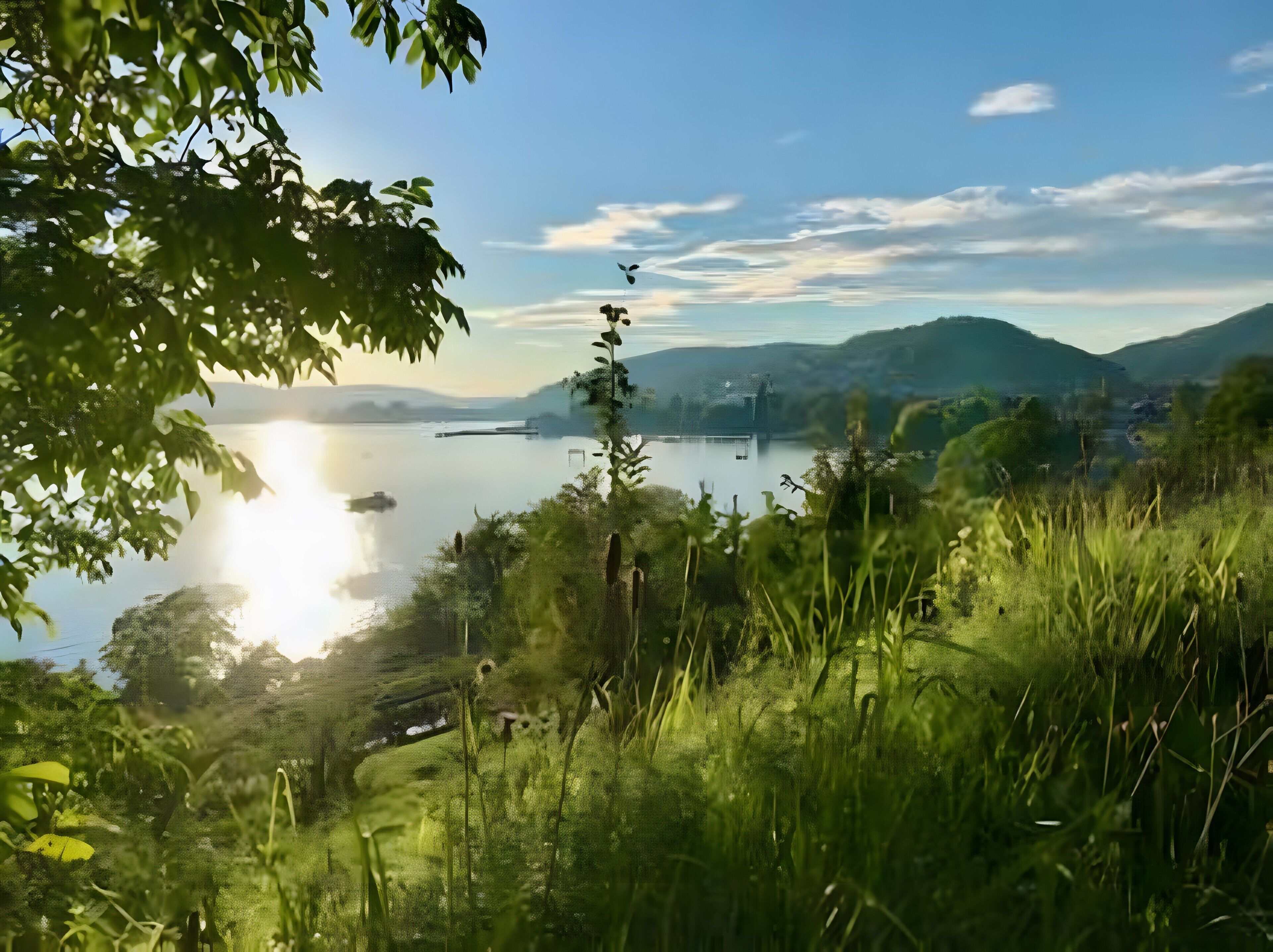 A natural landscape with a lake, hills, and greenery.