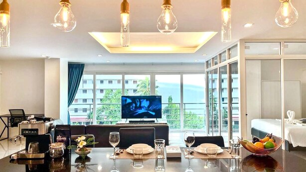 Une chambre d’hôtel dotée d’un coin repas, d’une télévision et d’une grande fenêtre offrant une vue dégagée.