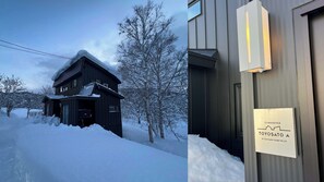 Une cabane en bois, dont le toit est recouvert de neige, et sur laquelle on peut lire une enseigne indiquant qu’il s’agit d’un hôtel Toyota A, appartenant à Yuki Family House PTE. LTD.