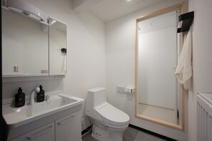 Une salle de bain moderne avec un lavabo blanc, un miroir et des toilettes.