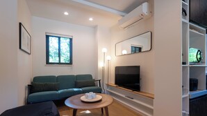 A modern living room with a sofa, a coffee table, a TV, and a bookshelf. - Niseko Town, Toyosato A near Hirafu, Niseko village and 30' Risutsu (Niseko-cho)
