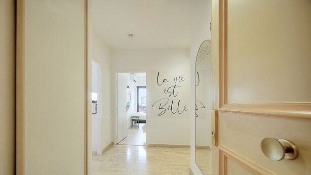 Un pasillo con un muro espejado y un letrero que dice 'la vie est belle'.