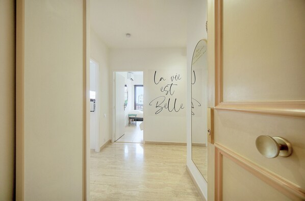 A hallway with a mirrored wall and a sign that reads "la vie est belle". - 2 rooms Balcony sea view A2B262 (Cannes)