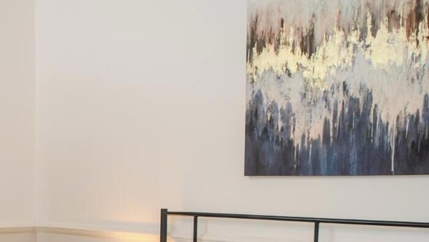 A hotel room with a bed, a painting on the wall, and a breakfast tray on the side. - Stylish 2-bed house ideal for business & family stays, garden, free parking. (Southampton)