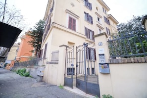 A building with a gated entrance, a mailbox, and a sign indicating a parking area.