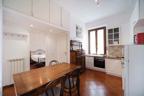Une cuisine équipée d’une table à manger, de chaises, de placards et d’une fenêtre.