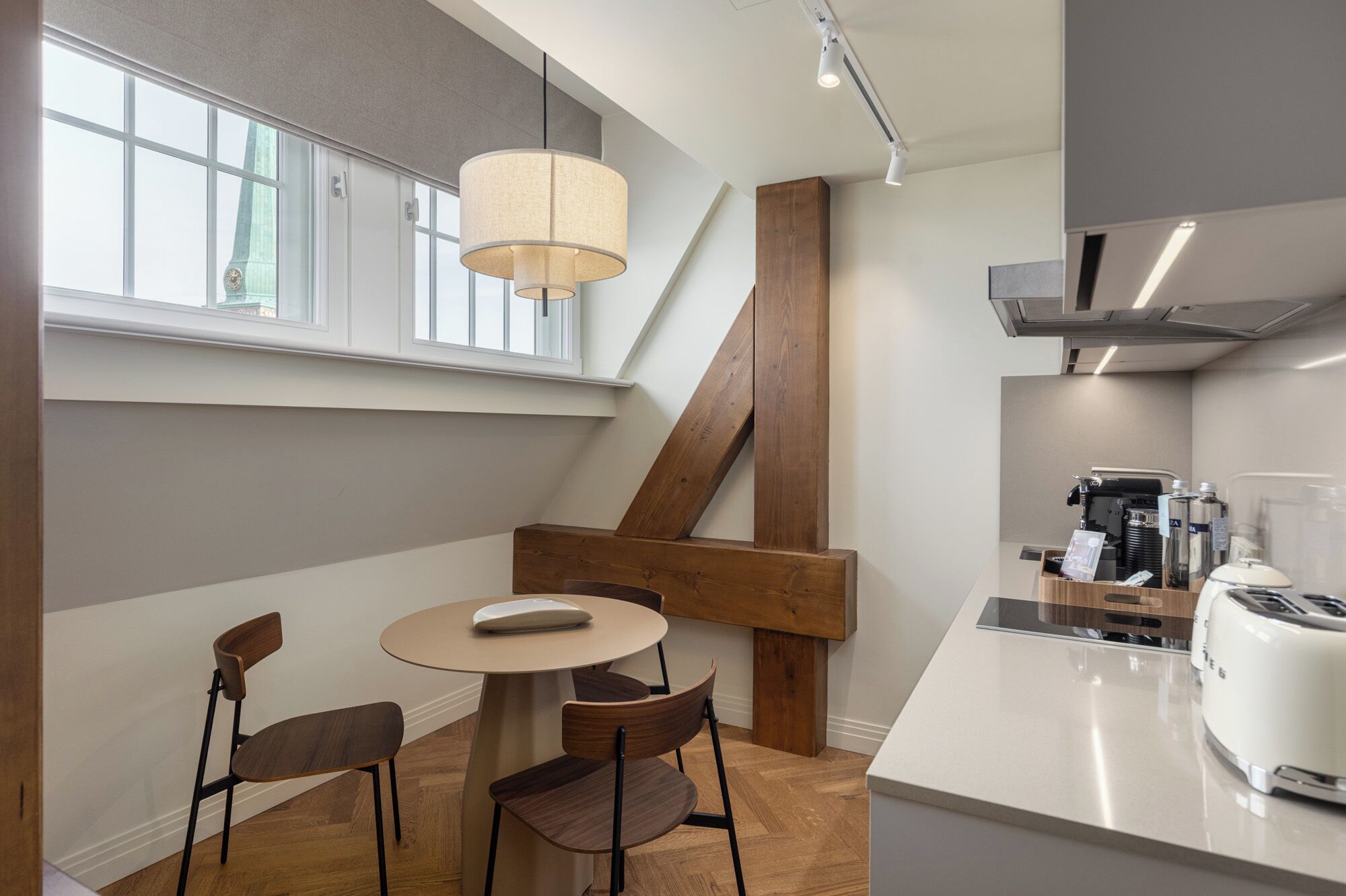 Una cocina moderna con comedor, una cafetera y un ventanal grande.