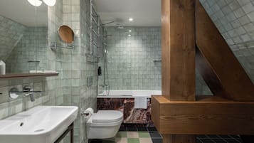 Et badeværelse med brusebad, toilet og håndvask.