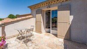 A patio with a table and chairs, a sliding glass door, and a tiled roof. - "Marcel Pagnol" Room at La Bastide des Mereuilles with Private Terrace, Wi-Fi & AC (Orange)