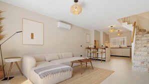 A modern living room with a sofa, coffee table, and a dining area with chairs. - Casa Eva | Ref. #97 (Estepona)