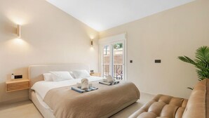 A bedroom with a bed, bedside table, and a plant. - Casa Eva | Ref. #97 (Estepona)