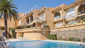 A poolside view of a building with a pool, balconies, and a palm tree. - Casa Eva | Ref. #97 (Estepona)