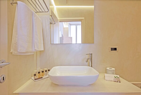 A modern bathroom with a large rectangular sink, a mirror, and a towel rack. - SUYTE Torino Centro (Turin)