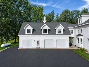 A two-story house with a garage, a driveway, and a lawn.