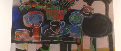 Una pintura que muestra una mesa con diversos objetos, como un jarrón, tazas y un bol.