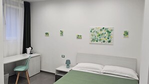 Une chambre moderne avec un lit simple, un bureau et une chaise.