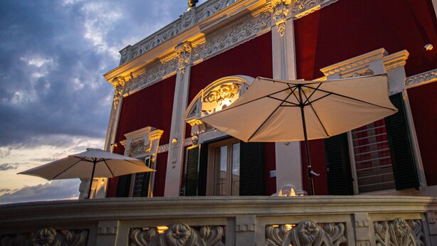 An outdoor seating area with ornate railings and umbrellas.
