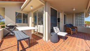 An outdoor patio with a grill, seating, and a view of the ocean. - Haven Waters 8 on the lakefront (Forster)