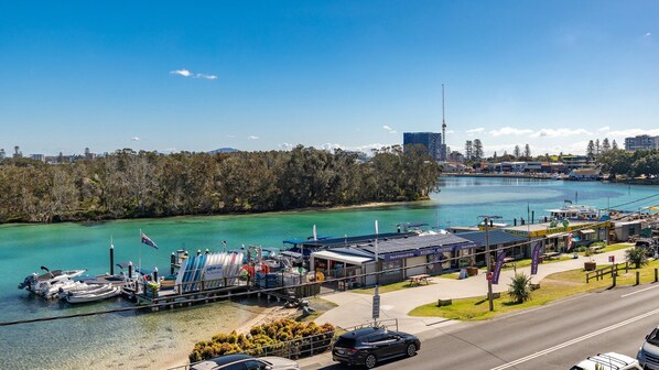 A waterfront property with a dock, boats, and a building with signage for a boathouse.