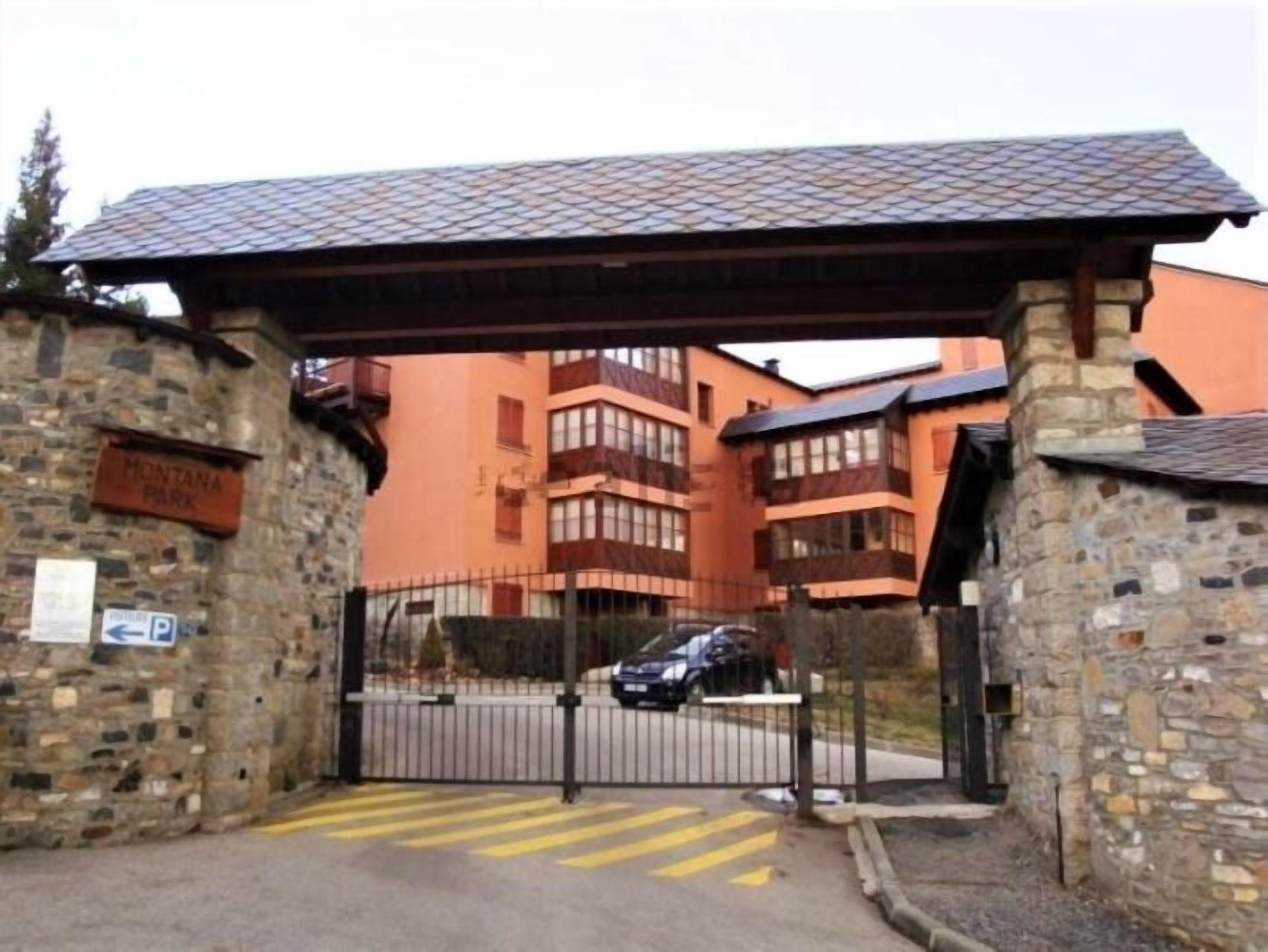 A gated entrance to a building with a stone wall and a sign reading 'Montana Park.'