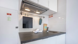 A modern kitchen with a built-in stove, a sink, and a towel rolled up on the counter.