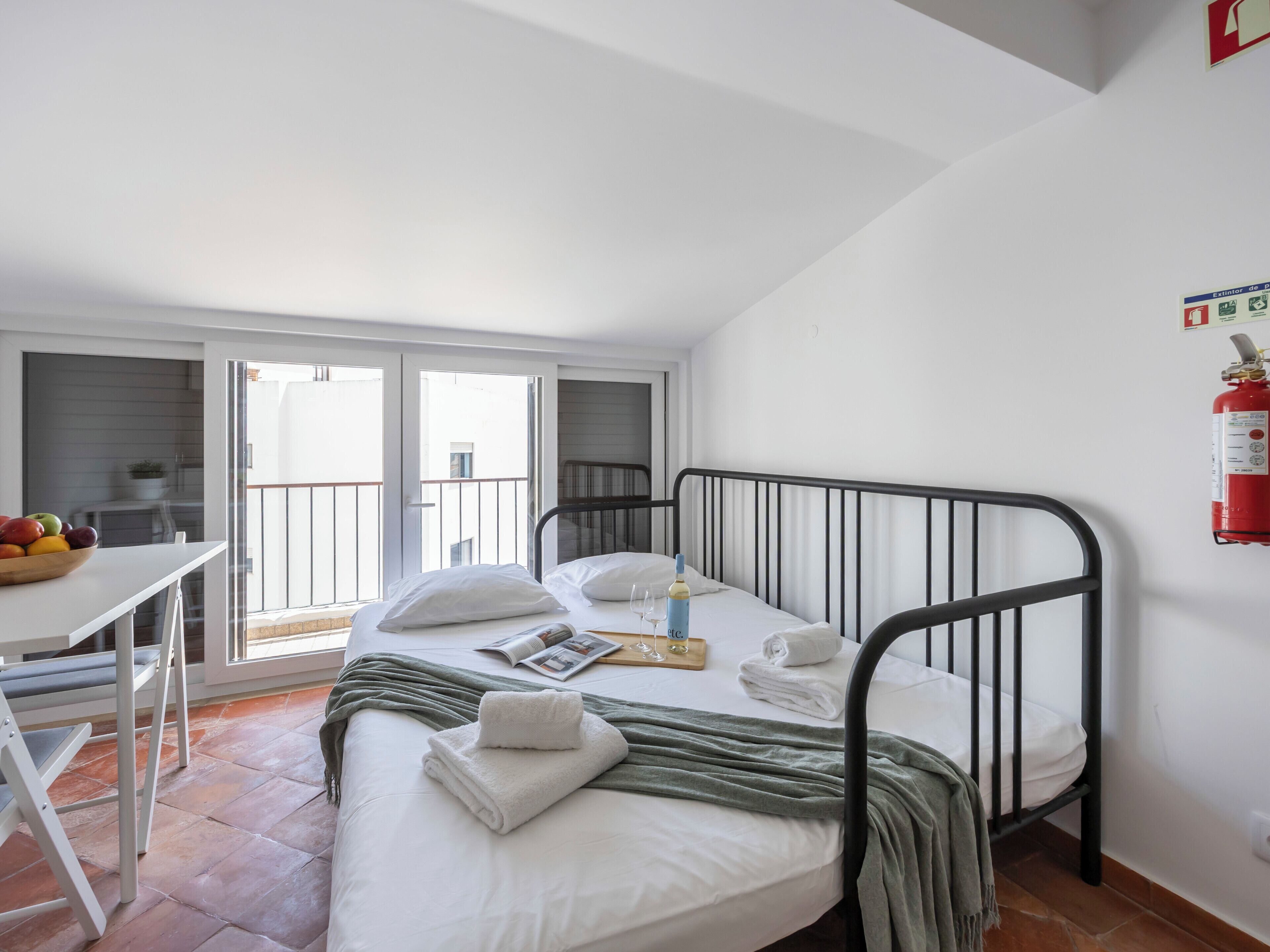 Une chambre à coucher avec un lit, un bureau et une fenêtre.