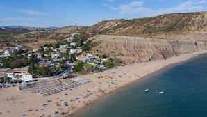 A coastal town with a beach, houses, and cliffs.