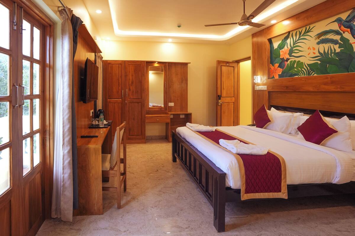 A bedroom with a bed, a desk, a chair, a wardrobe, and a ceiling fan.