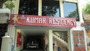 A building with a sign reading "Kumar Residency" and a parked car in the entrance. - Le Kumar Residency (Puducherry)