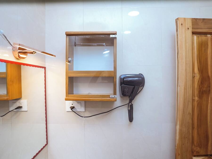 A room with a wooden cabinet, a telephone, and a wall-mounted light fixture.