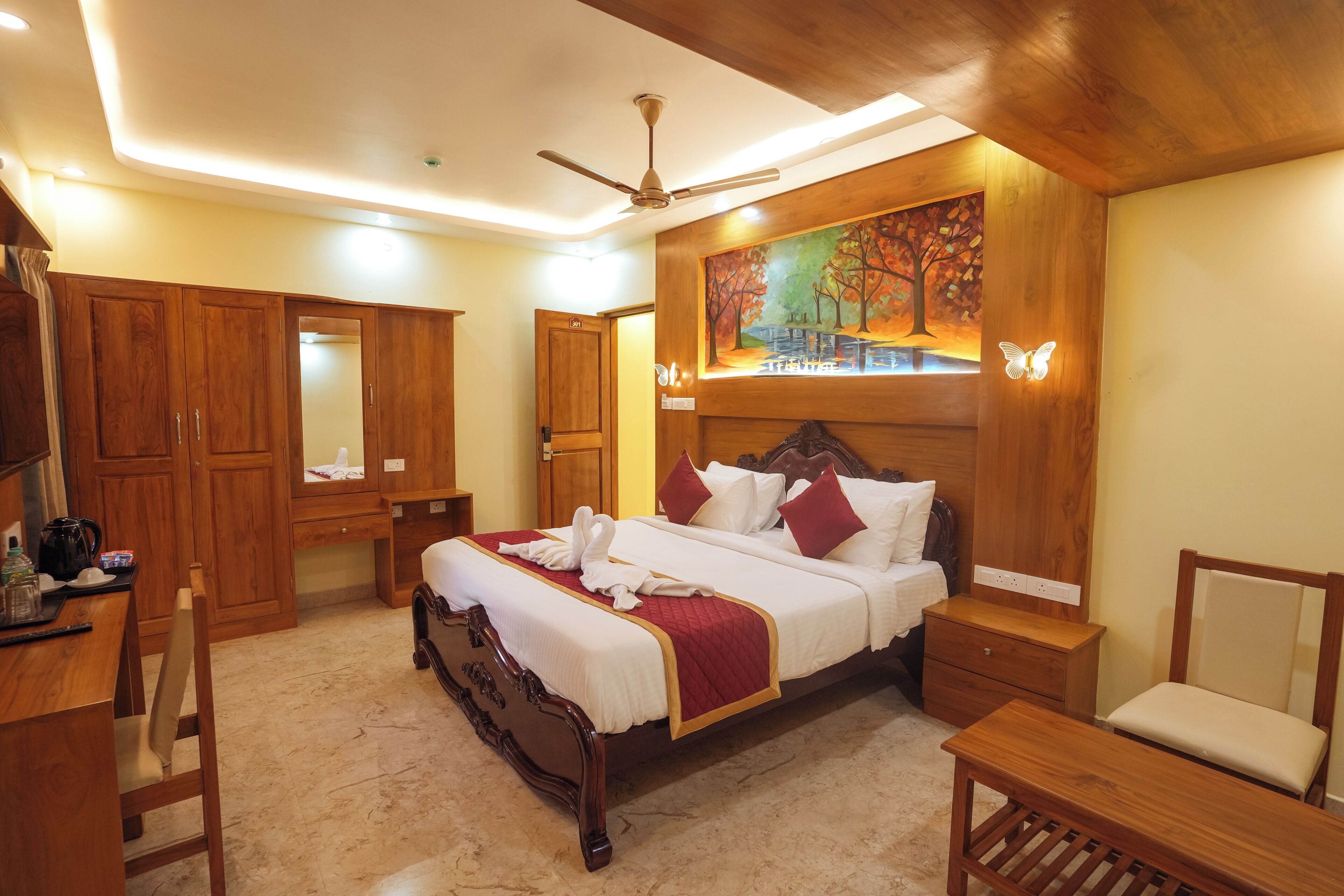A bedroom with a wooden bed, a desk, a chair, and a nightstand.