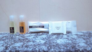 A dental kit with two bottles and a bar of soap on a marble surface. - Le Kumar Residency (Puducherry)