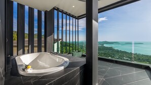 A modern bathroom with a large bathtub, a marble countertop, and a view of a coastal landscape. - SOMA 4 Bedrooms SEAVIEW Pool Villa (Koh Samui)
